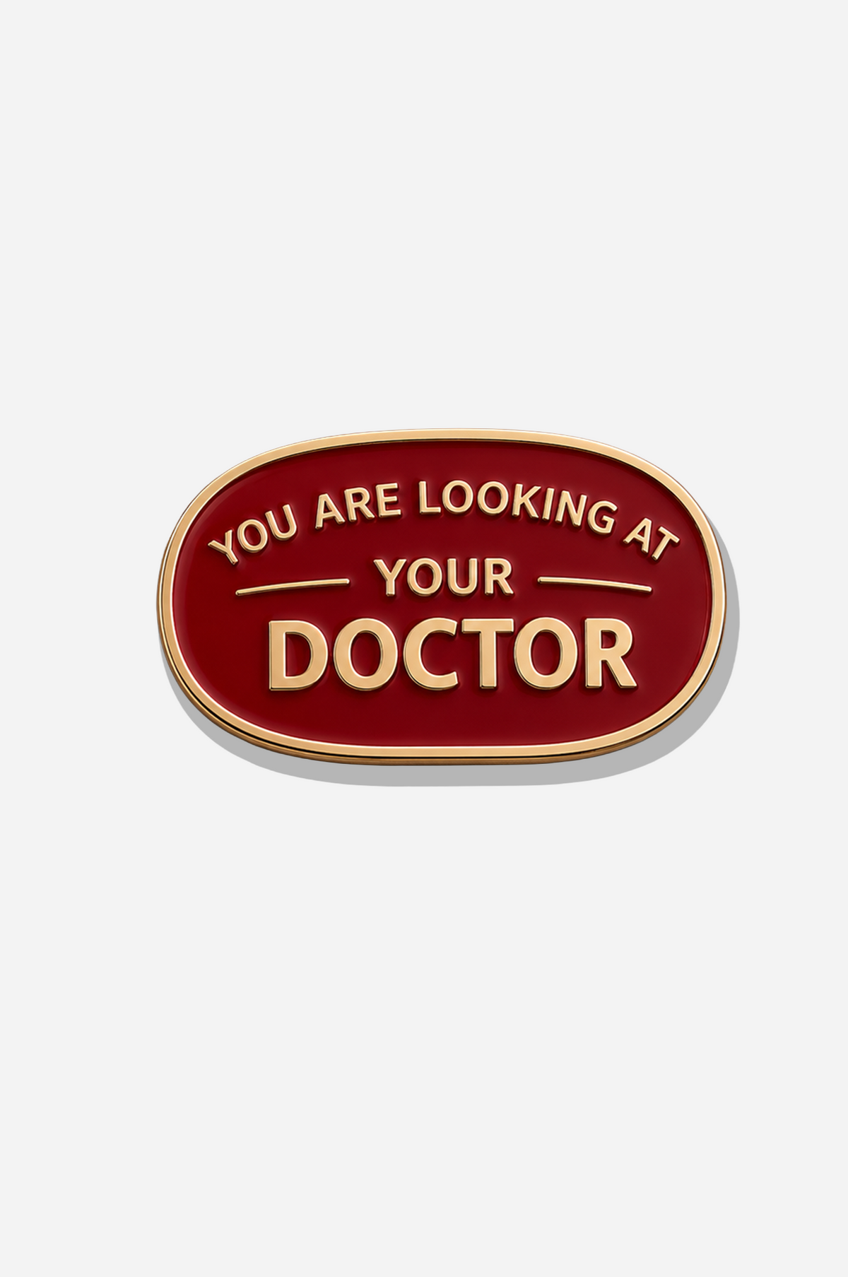 Oval red Doctor Mark medical brooch with gold-tone borders and the phrase “You Are Looking at Your Doctor” in gold lettering.