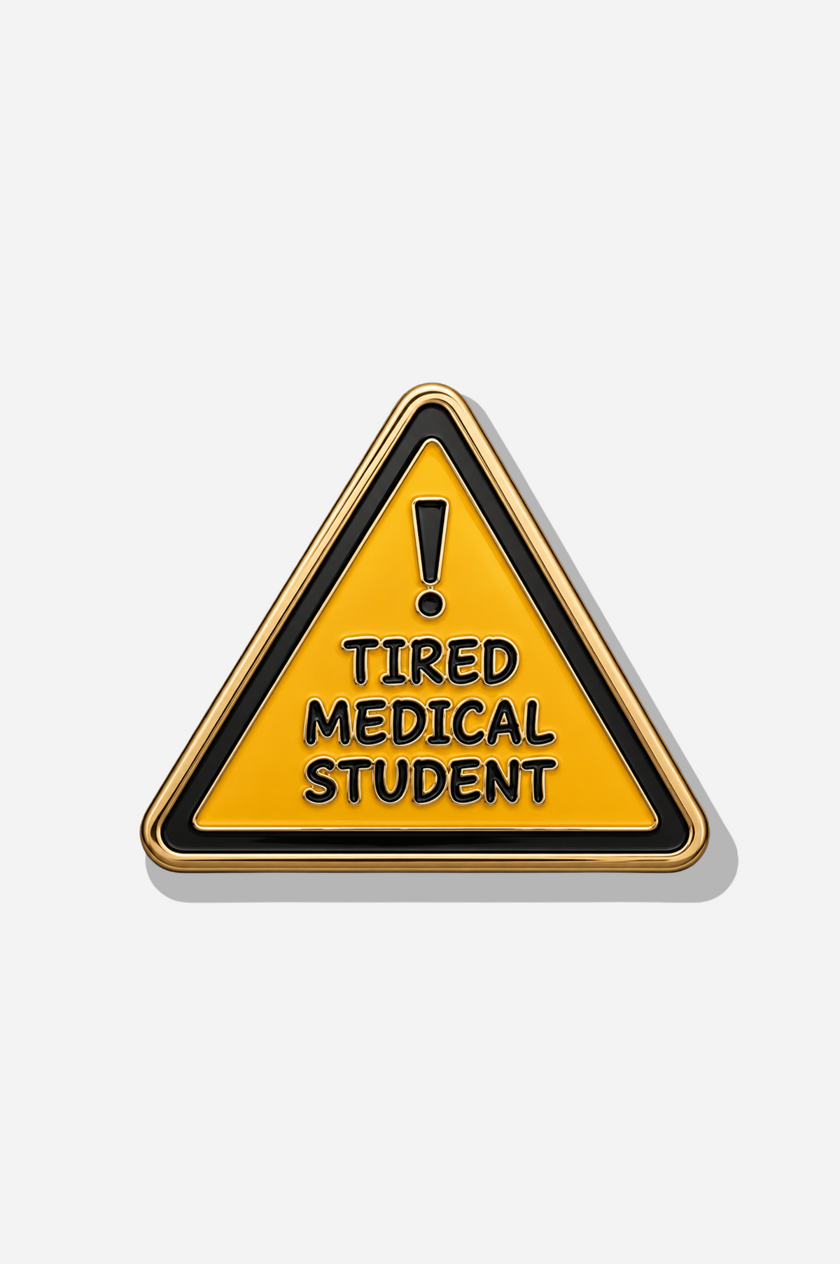Yellow triangular Lazy Doc brooch with a black warning symbol, gold-tone edging, and the words “Tired Medical Student.”